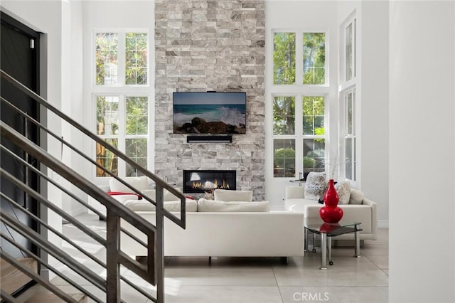 3 Bridgeport Rd, Newport Coast, CA 92657 - living room with a high ceiling, a stone fireplace, and plenty of natural light