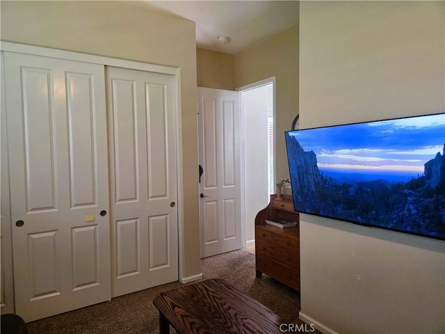 bedroom with dark carpet and a closet