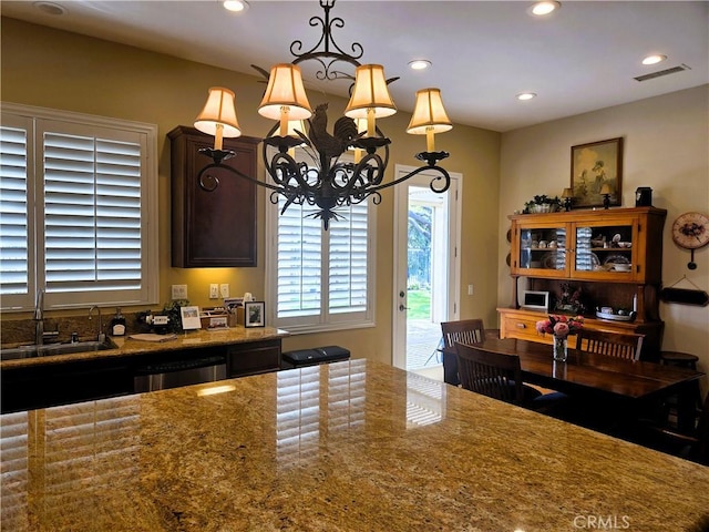 kitchen featuring a sink, a healthy amount of sunlight, an inviting chandelier, and visible vents