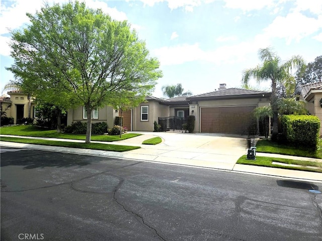 ranch-style house featuring an attached garage, stucco siding, driveway, and a front yard