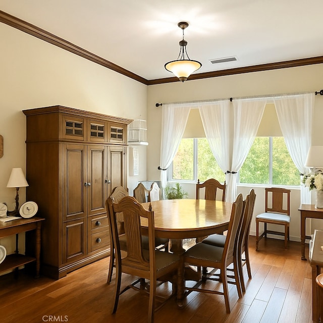 dining area with visible vents, ornamental molding, and light wood-style floors
