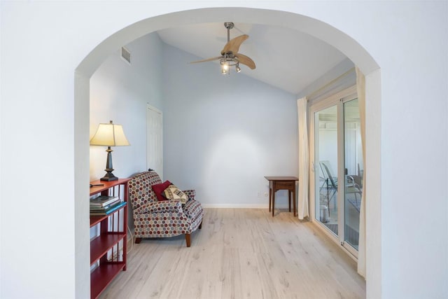 sitting room with a ceiling fan, visible vents, wood finished floors, baseboards, and lofted ceiling
