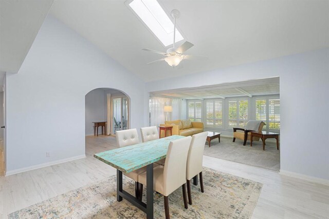 3685 Vista Campana N Unit 61, Oceanside, CA 92057 - dining space with arched walkways, ceiling fan, vaulted ceiling, light wood finished floors, and a skylight