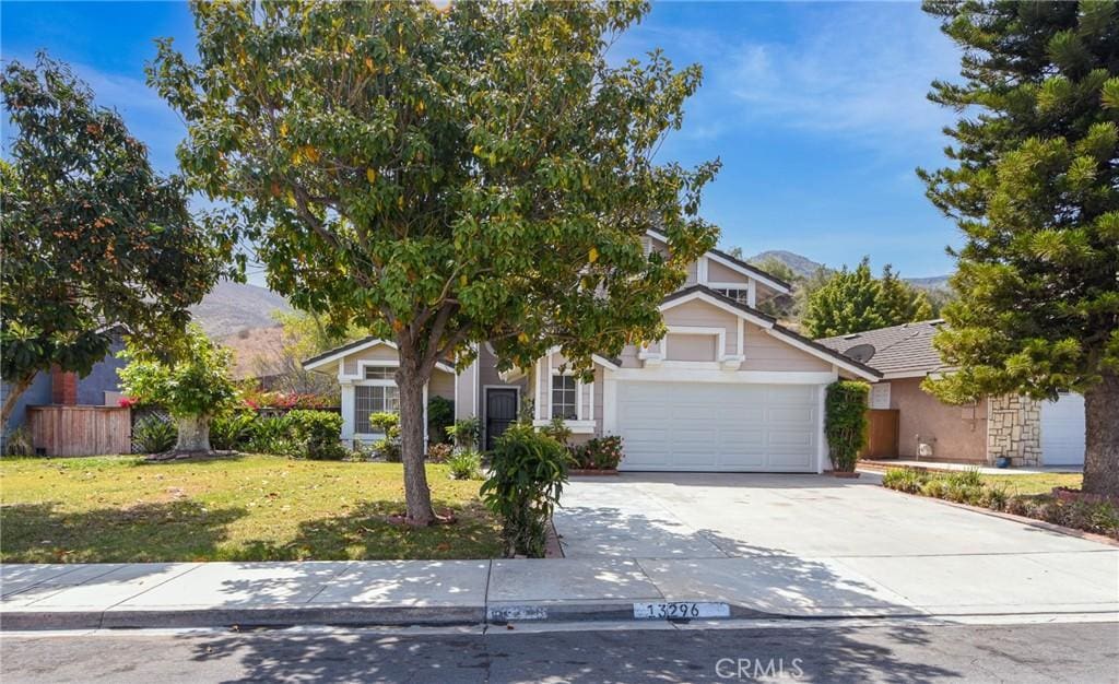 13296 March Way, Corona, CA 92879 - view of property hidden behind natural elements with an attached garage, a front lawn, a mountain view, and driveway