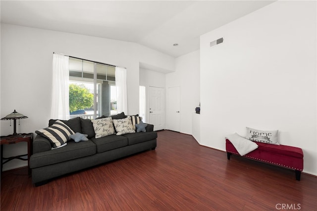 living area with visible vents, wood finished floors, and lofted ceiling