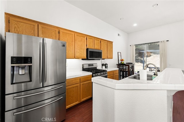 kitchen featuring tile countertops, visible vents, appliances with stainless steel finishes, dark wood finished floors, and a sink