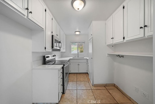 kitchen featuring light countertops, stainless steel appliances, white cabinetry, and a sink
