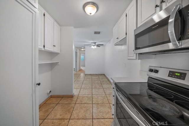 kitchen featuring visible vents, baseboards, white cabinets, a ceiling fan, and stainless steel appliances