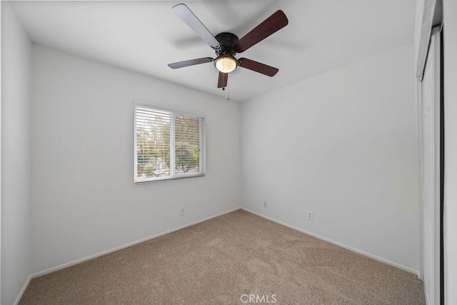 spare room with baseboards, ceiling fan, and carpet flooring
