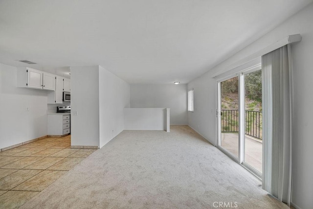 unfurnished living room featuring visible vents, baseboards, and light carpet