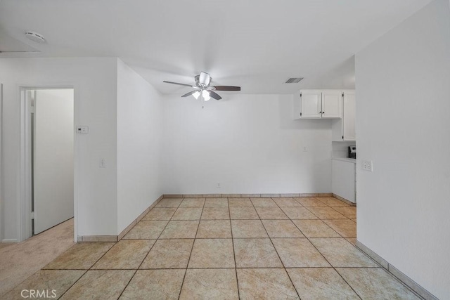empty room featuring visible vents, a ceiling fan, baseboards, and light tile patterned floors