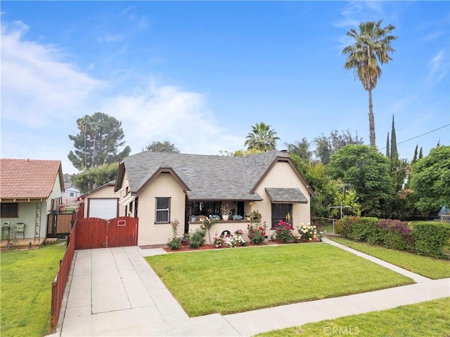 view of front of house featuring fence, a gate, stucco siding, and a front yard