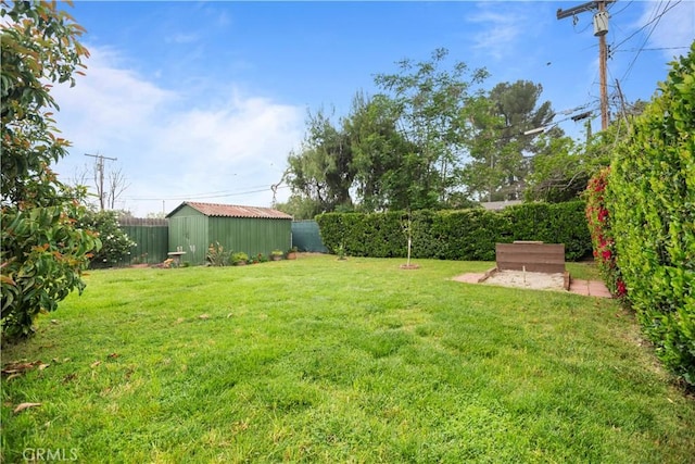 view of yard with a fenced backyard, an outbuilding, and a storage shed