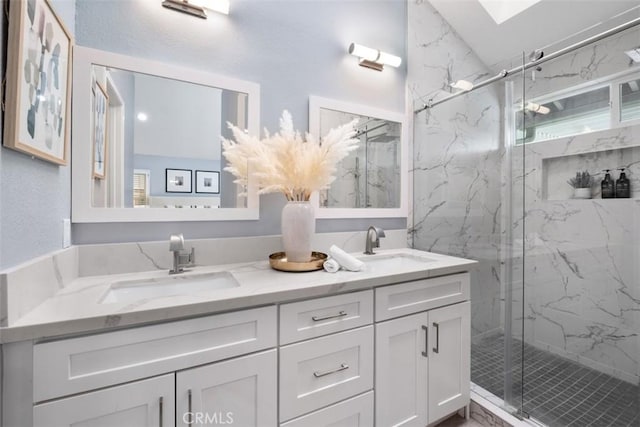 bathroom with a marble finish shower and double vanity