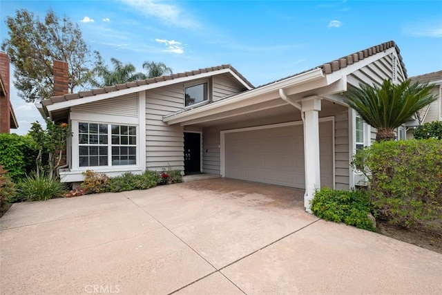 8 Recodo, Irvine, CA 92620 - view of front of home with driveway, a garage, and a chimney
