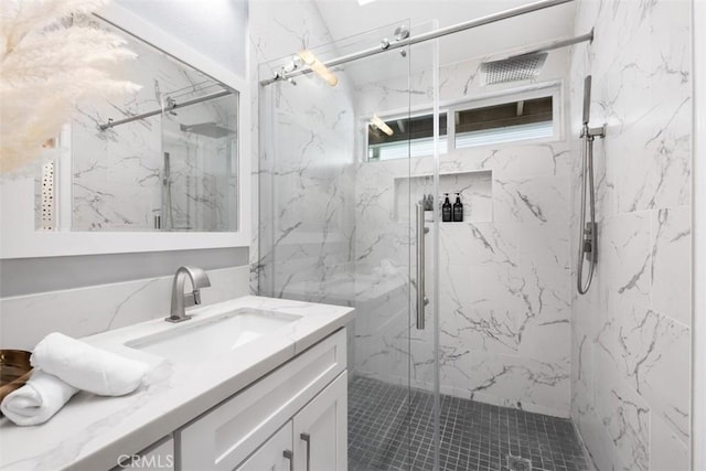 full bathroom featuring a marble finish shower and vanity
