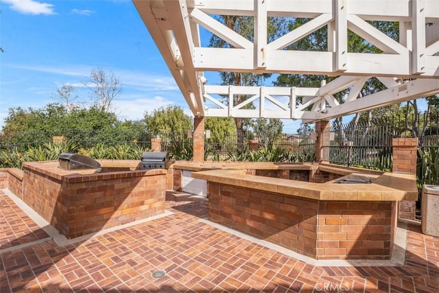 view of patio / terrace featuring an outdoor kitchen, area for grilling, fence, and a gazebo
