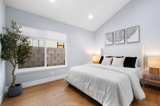 bedroom with wood finished floors, recessed lighting, baseboards, and lofted ceiling