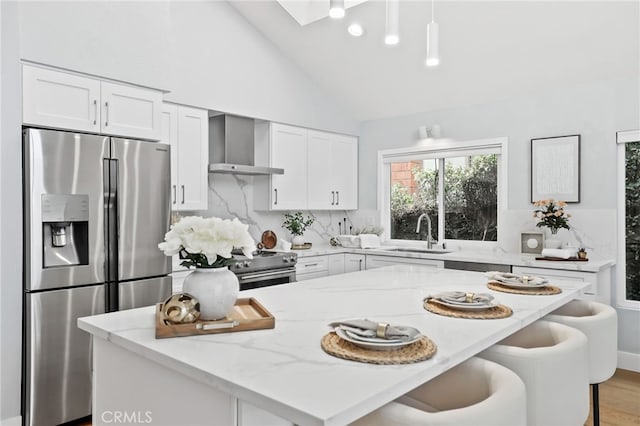 8 Recodo, Irvine, CA 92620 - kitchen featuring appliances with stainless steel finishes, wall chimney range hood, a sink, tasteful backsplash, and light stone counters