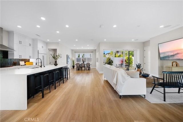 living room with light wood-style floors, baseboards, plenty of natural light, and recessed lighting