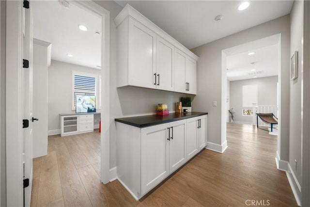 corridor featuring light wood-style floors, recessed lighting, and baseboards