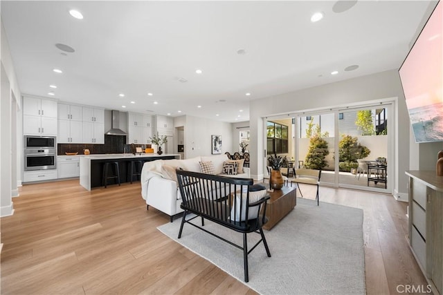 living room with baseboards, light wood finished floors, and recessed lighting
