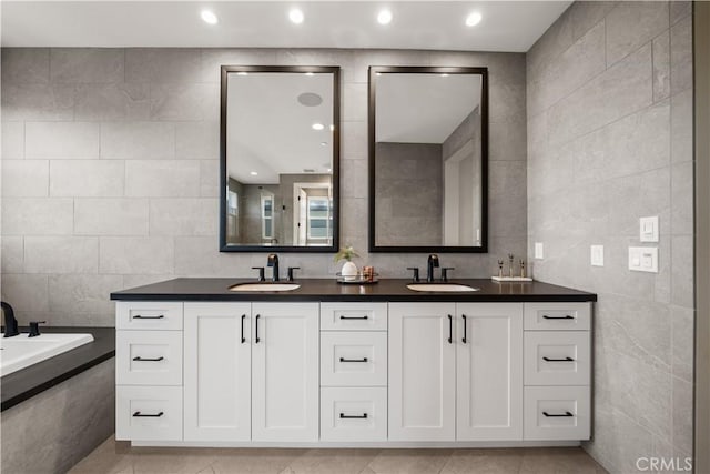 full bathroom with a sink, tile walls, tile patterned floors, and double vanity