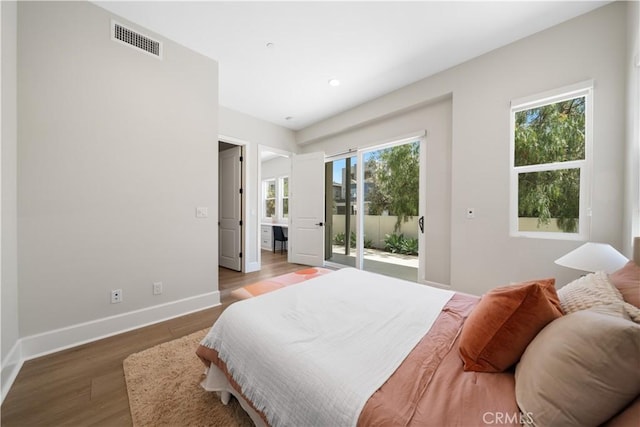 bedroom with access to exterior, recessed lighting, baseboards, wood finished floors, and visible vents