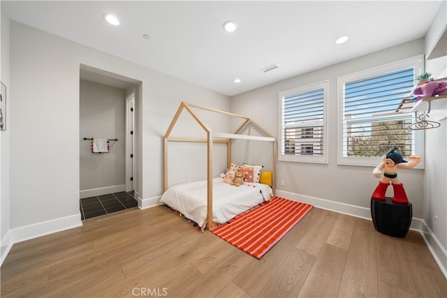 bedroom featuring baseboards, recessed lighting, and wood finished floors