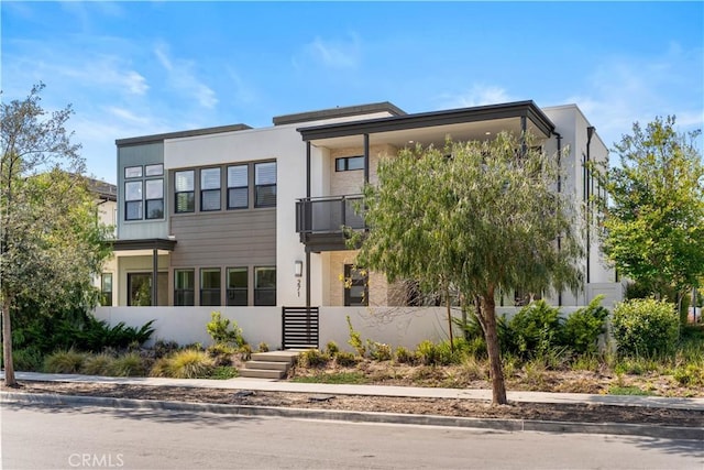 modern home featuring stucco siding and a balcony