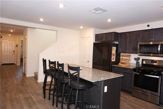 1322 Division Ct, Hemet, CA 92543 - kitchen with stainless steel appliances, dark wood-type flooring, light stone countertops, a center island, and recessed lighting