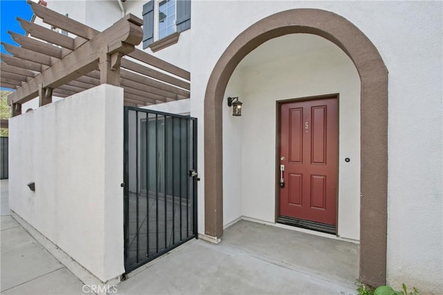 entrance to property with a gate and stucco siding