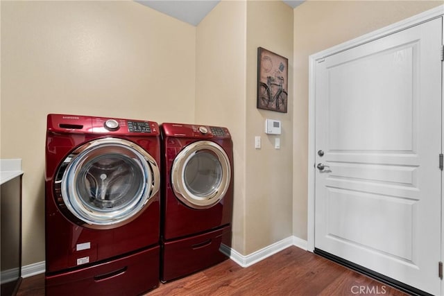 laundry area with baseboards, laundry area, independent washer and dryer, and wood finished floors