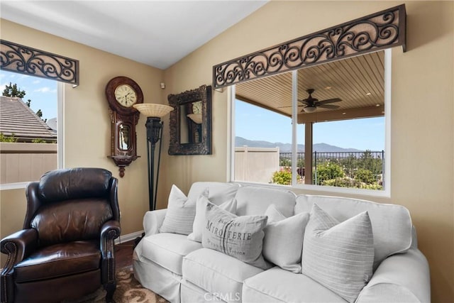 living area featuring plenty of natural light, a mountain view, and ceiling fan