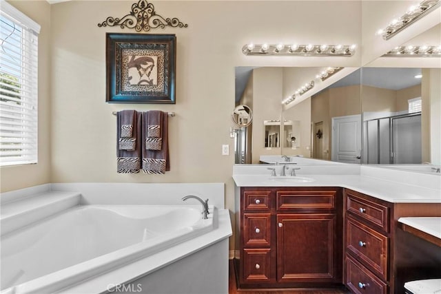 full bath featuring vanity, a garden tub, and a stall shower