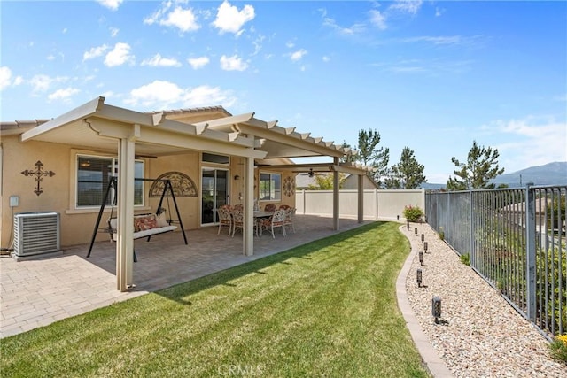 back of house with central AC, stucco siding, a fenced backyard, a patio area, and a yard