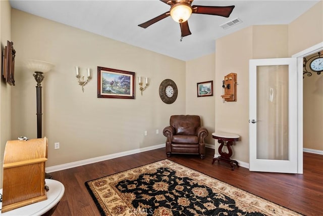 living area featuring visible vents, wood finished floors, baseboards, ceiling fan, and french doors