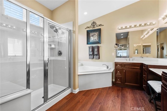 bathroom featuring vanity, a bath, a shower stall, and wood finished floors