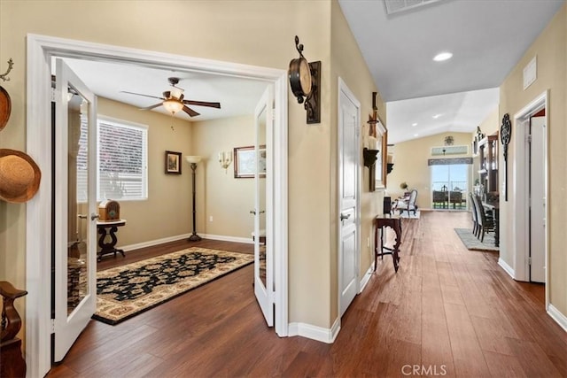 hallway with baseboards, vaulted ceiling, and dark wood-type flooring