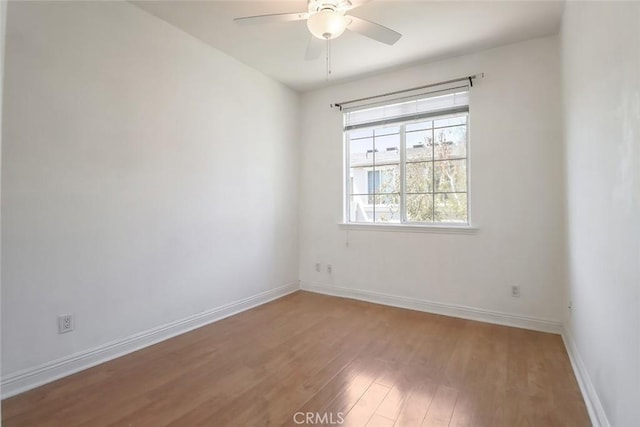 spare room with a ceiling fan, baseboards, and light wood-style flooring