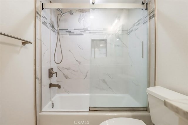 full bathroom featuring combined bath / shower with glass door and toilet