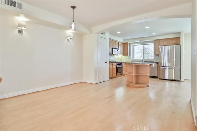 kitchen with visible vents, arched walkways, light wood-style flooring, appliances with stainless steel finishes, and backsplash