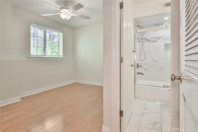 bathroom with baseboards, ceiling fan, combined bath / shower with glass door, and visible vents