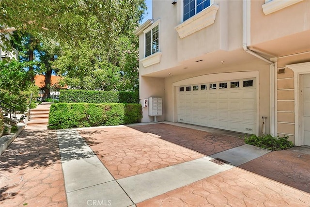 view of home's exterior featuring a garage, stucco siding, and driveway