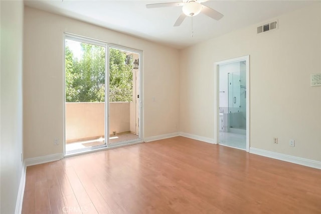 spare room with baseboards, a ceiling fan, wood finished floors, and visible vents