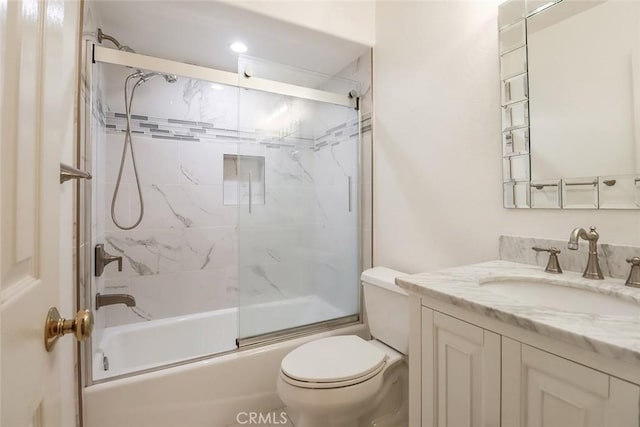 full bathroom featuring toilet, enclosed tub / shower combo, and vanity