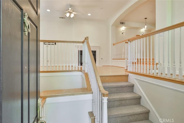 stairs featuring arched walkways, ceiling fan, recessed lighting, and visible vents
