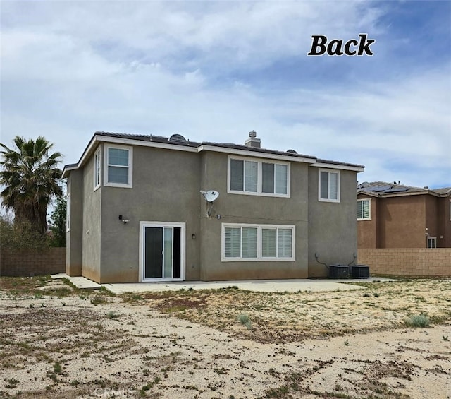 back of property with fence and stucco siding