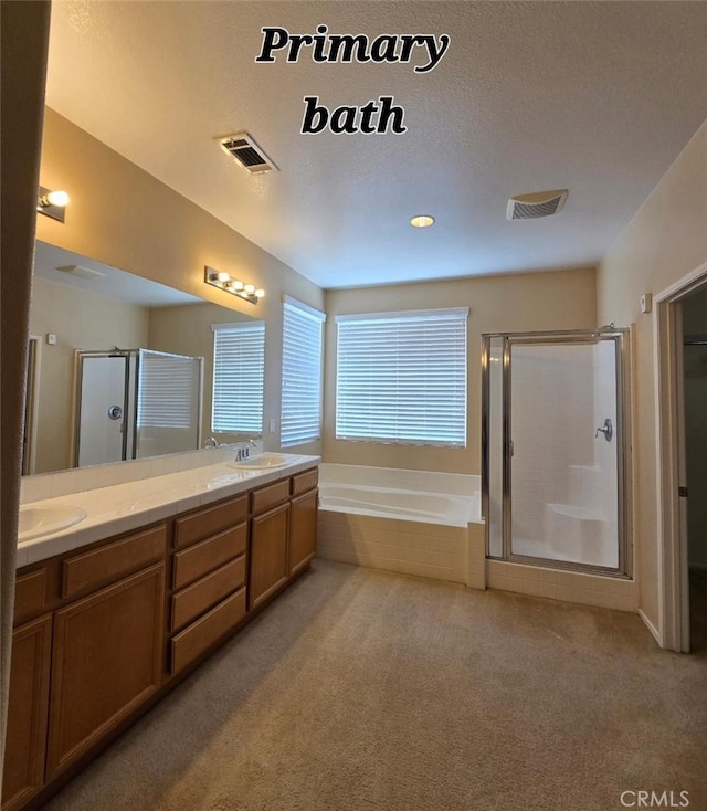 bathroom featuring visible vents, double vanity, a bath, a sink, and a stall shower