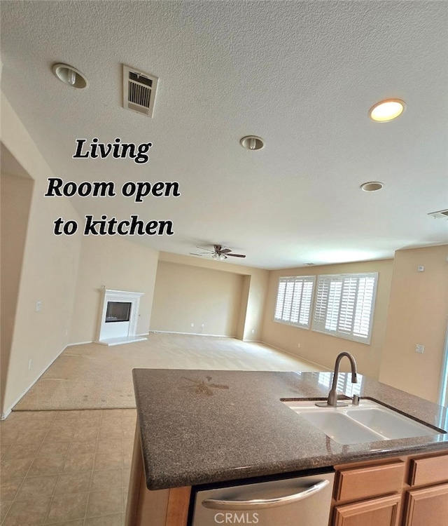 kitchen with stainless steel dishwasher, a ceiling fan, open floor plan, an island with sink, and a sink